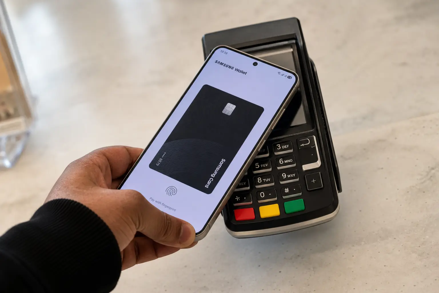 Eine Person bezahlt in einem Geschäft mit einem Samsung-Smartphone über die Wallet-App.