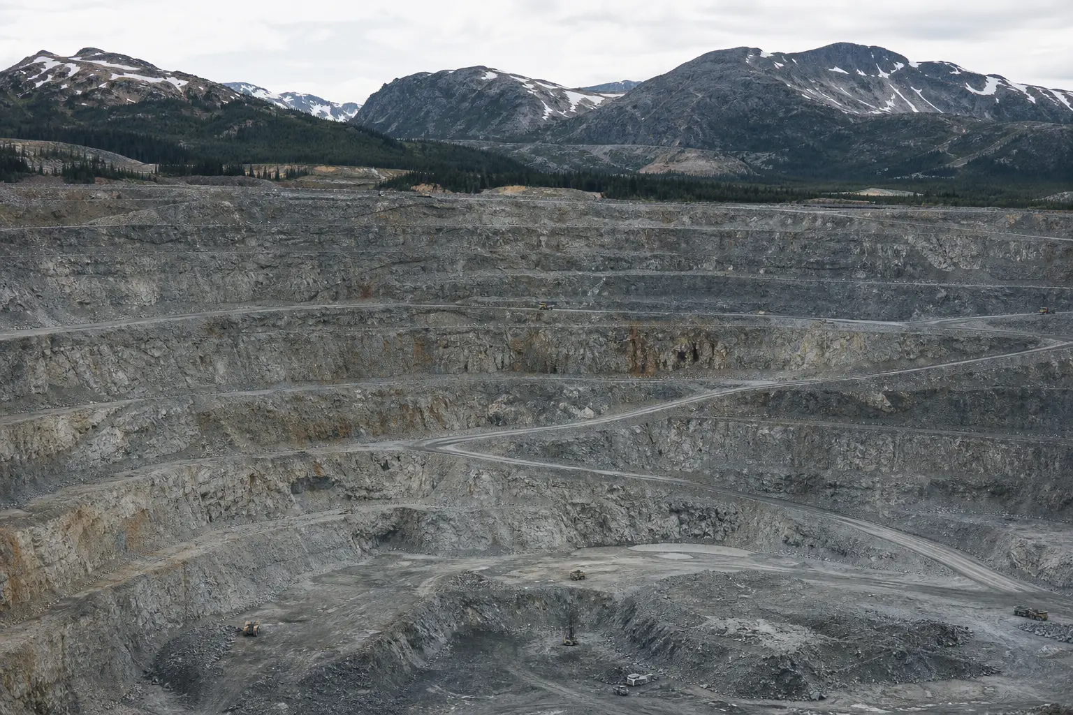 The existing Red Chris open-pit copper mine seen head-on across its terraced pit benches and haul roads set in remote northwestern British Columbia mountains un