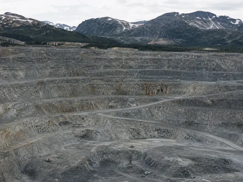 The existing Red Chris open-pit copper mine seen head-on across its terraced pit benches and haul roads set in remote northwestern British Columbia mountains un