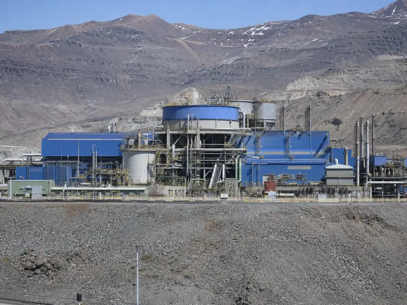 The surface facilities and processing plant of Codelco's El Teniente underground copper mine set against the surrounding Andean mountainside under flat daylight