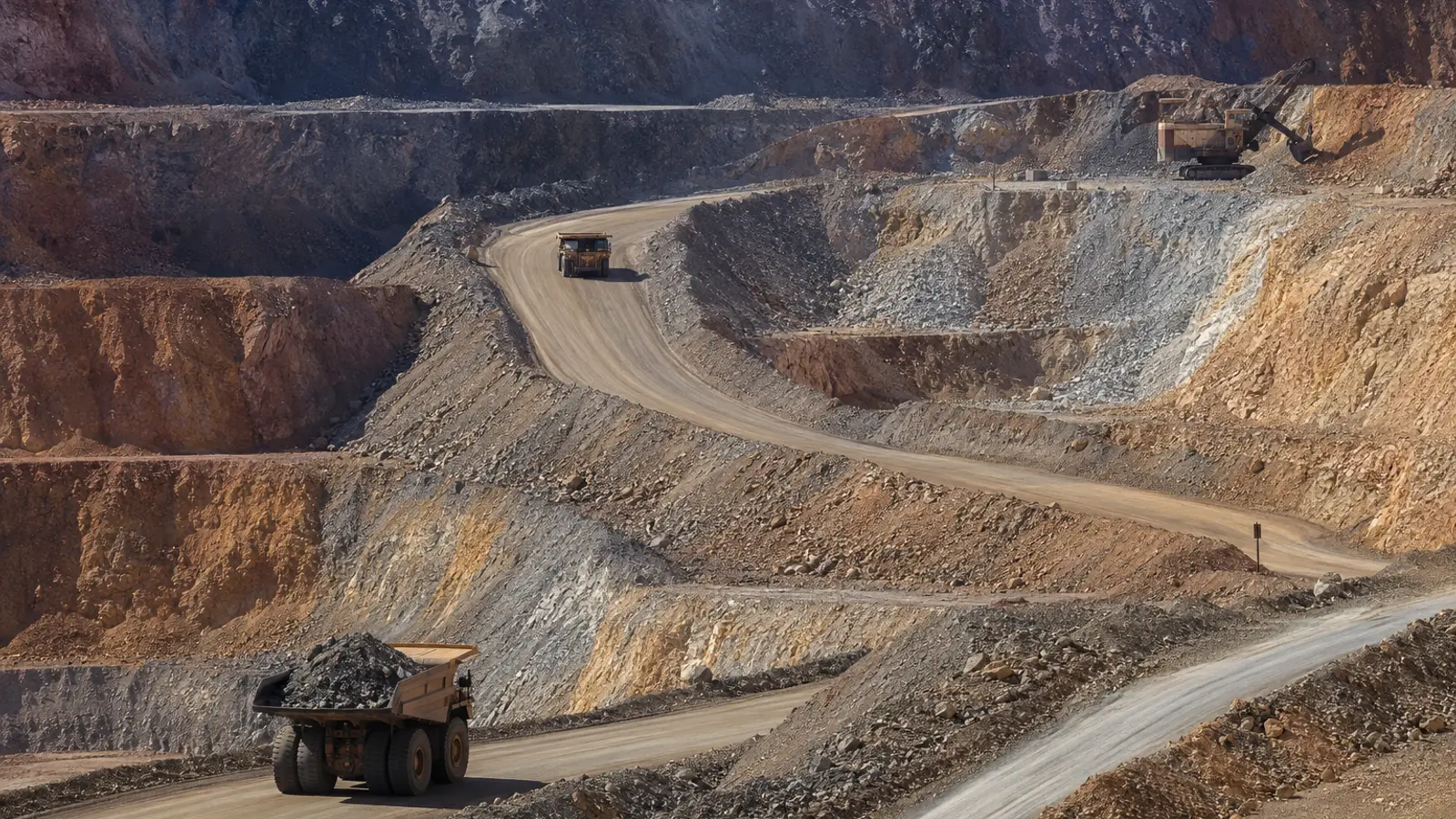 Dump trucks hauling material out of an open-pit copper mine. 