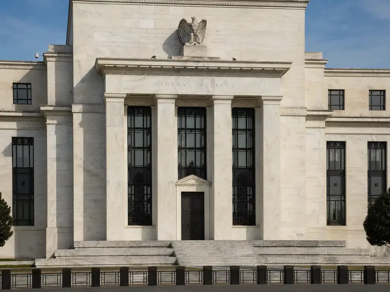 A straight front-on daytime view of the Marriner S. Eccles Federal Reserve building in Washington with its stone facade and Federal Reserve inscription above th