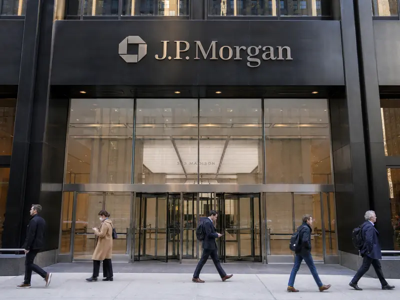 A straight front-on daylight view of the J.P. Morgan office tower entrance in Manhattan, with the firm's octagon logo and wordmark visible incidentally on the b