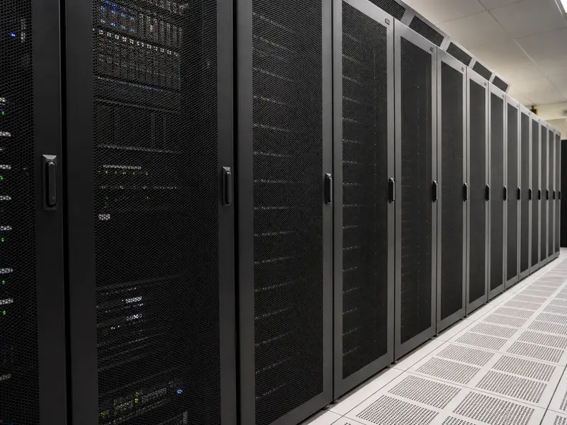 A row of black server racks inside a secure government-style data center room, photographed in plain neutral light.. Approved.