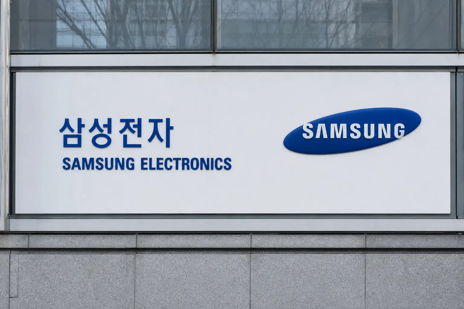 The Samsung Electronics sign and logo mounted on the exterior of its Seocho headquarters building in Seoul, photographed head-on at eye level in flat daytime li