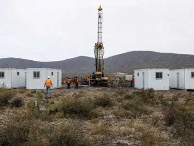 A head-on view of a silver exploration project site on scrubby semi-arid highland in Guanajuato, Mexico, with white portable container offices lined up beside a