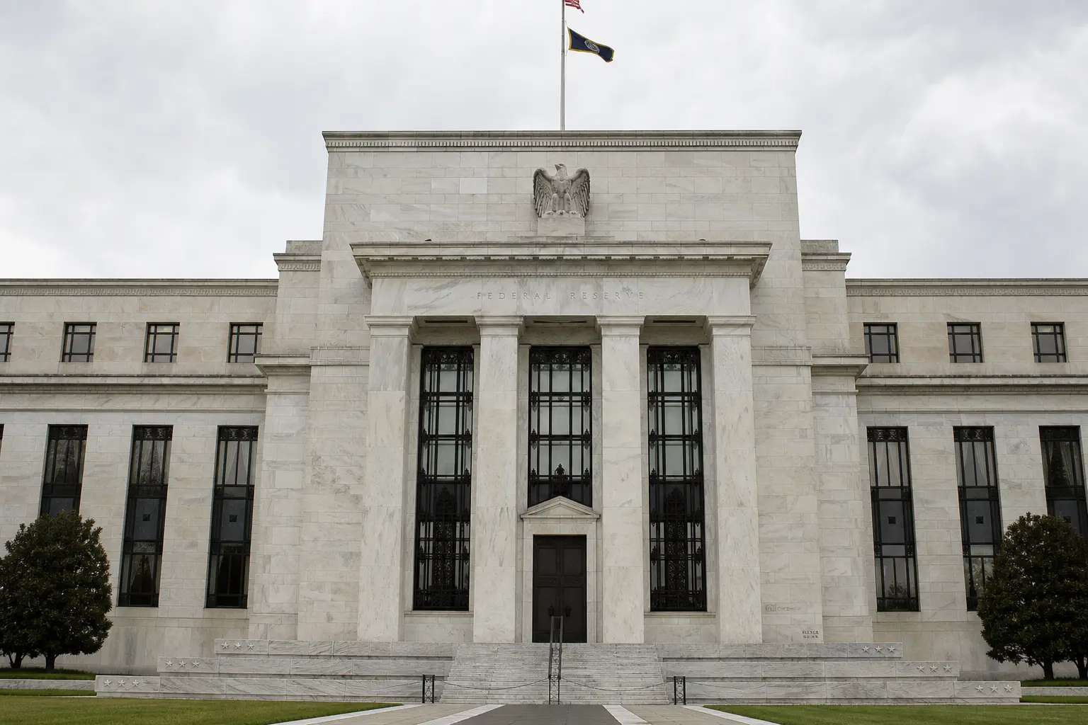 A front-on daylight photograph of the Marriner S. Eccles Federal Reserve building in Washington, its stone facade and columns filling the frame under an overcas
