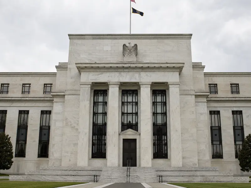 A front-on daylight photograph of the Marriner S. Eccles Federal Reserve building in Washington, its stone facade and columns filling the frame under an overcas